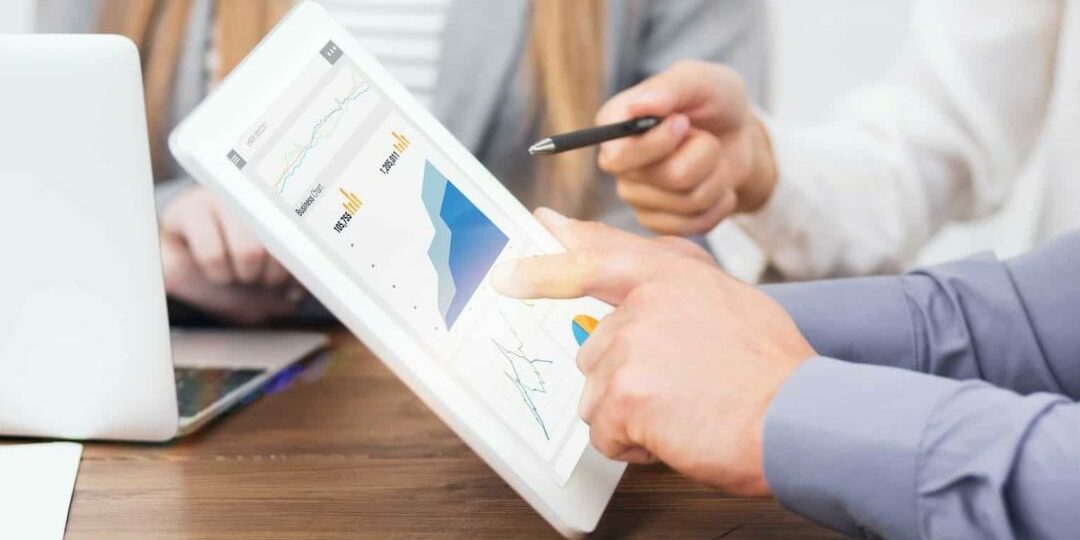 Web marketing managers with gadgets working on paid search and SEO strategies, closeup of hands